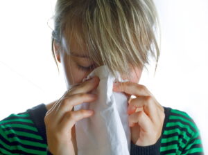 A woman blowing her nose